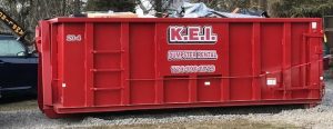 A full dumpster from a dumpster rental services company called KEI.
