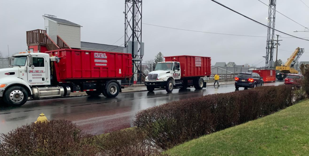 A fleet of KEI trucks delivers roll-off dumpsters in various sizes to a construction site in Butler County. 