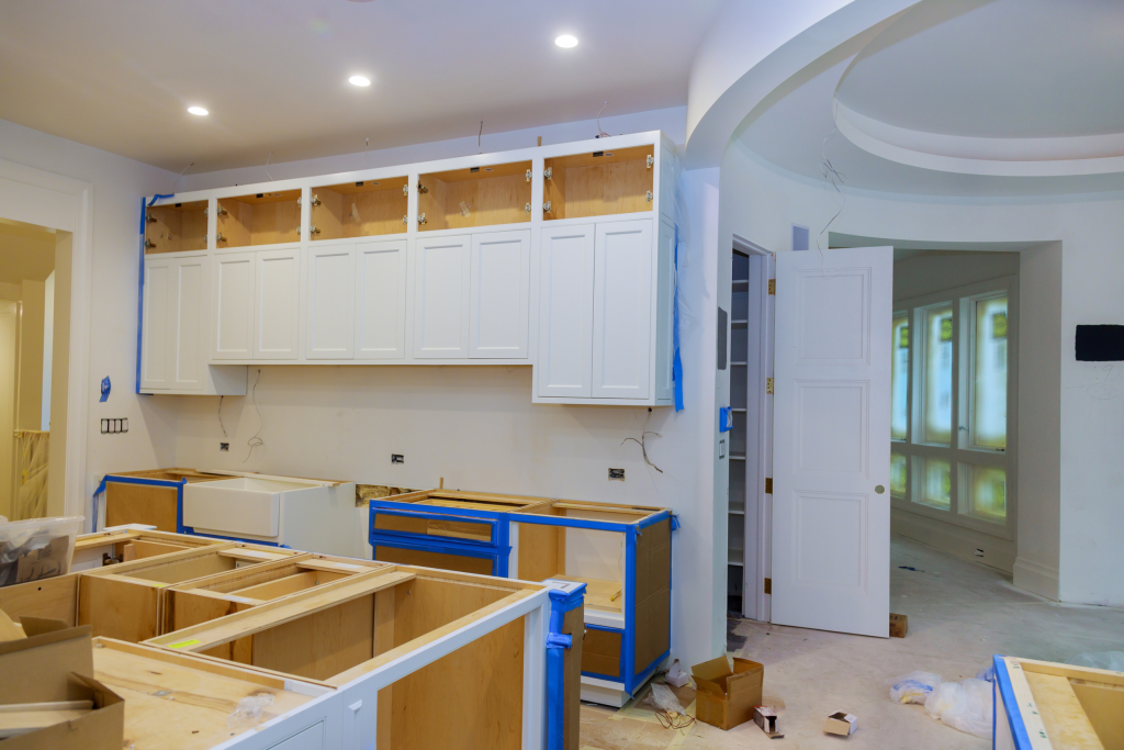 A kitchen in the middle of a renovation project, with new cabinets being installed. Dumpster sizes matter when using them to collect debris for home renovations. 