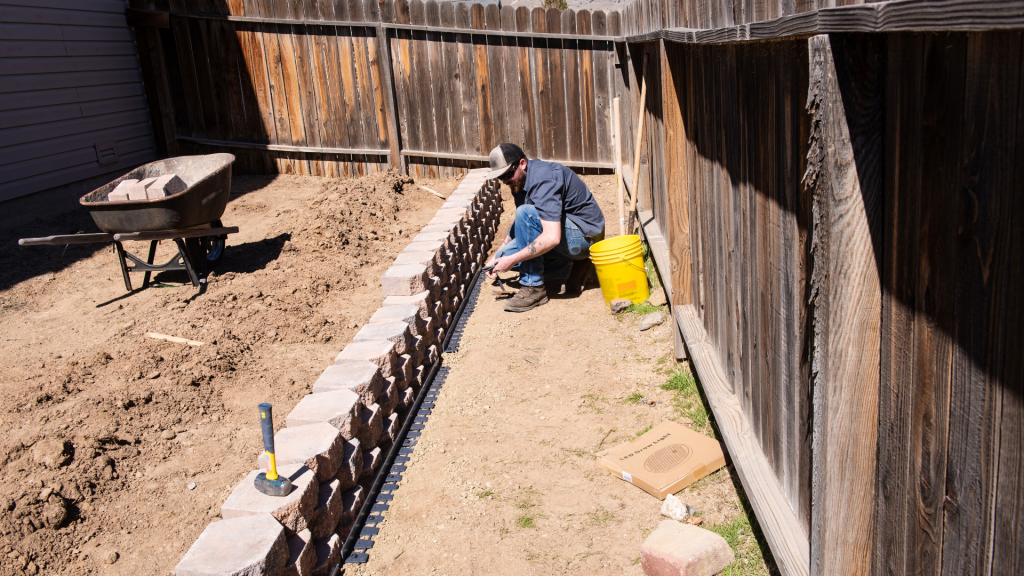 A man builds a retaining wall in his back yard in Slippery Rock. 