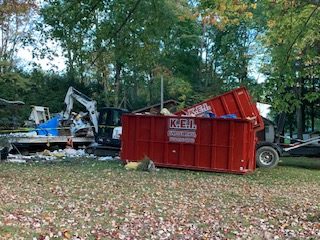 A KEI Dumpster Rental truck delivers construction dumpsters. 