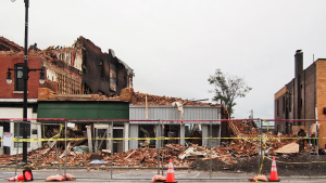Several businesses on a block that were destroyed by fire await construction dumpsters and a restoration crew.