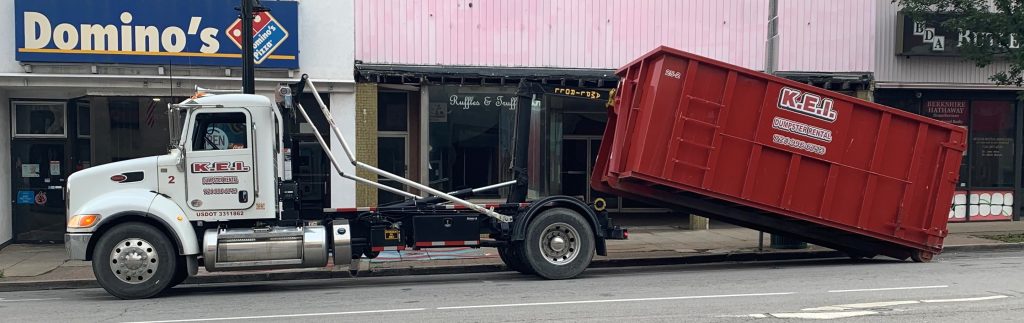 A KEI truck delivers a dumpster to a City of Butler business. The dumpster will occupy an on-stree parking space, which may require a permit in some municipalities. 
